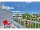 Relaxing balcony with red chair and tennis court view at 6800 Placida Rd # 281, Englewood, FL 34224