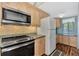 Modern kitchen with stainless steel appliances and wood cabinets at 6800 Placida Rd # 281, Englewood, FL 34224