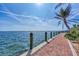 Brick paved walkway leading to a wooden dock, overlooking calm water under a sunny sky at 6800 Placida Rd # 281, Englewood, FL 34224