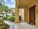 Condo building entry with brown door and walkway at 7147 Boca Grove Pl # 103, Lakewood Ranch, FL 34202