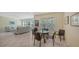 Bright dining area with glass-top table and wicker chairs, adjacent to living room at 16450 Gloria Ln # 105, Nokomis, FL 34275