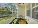 Screened patio with small table and chairs at 16450 Gloria Ln # 105, Nokomis, FL 34275