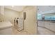 Laundry room with washer, dryer, and kitchen access at 16450 Gloria Ln # 105, Nokomis, FL 34275