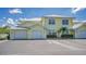 Front view of a yellow two-story building with two garages at 16450 Gloria Ln # 105, Nokomis, FL 34275