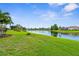 Lush green backyard featuring a tranquil lake, mature trees, and well-manicured landscaping at 310 Lake Tahoe Ct, Englewood, FL 34223