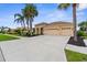 Charming home featuring a well-manicured lawn, mature palm trees, and a spacious three-car garage at 310 Lake Tahoe Ct, Englewood, FL 34223
