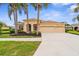 Charming home featuring a well-manicured lawn, mature palm trees, and a spacious three-car garage at 310 Lake Tahoe Ct, Englewood, FL 34223
