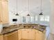 Kitchen island sink with granite countertops, cream colored cabinets and stainless steel dishwasher at 310 Lake Tahoe Ct, Englewood, FL 34223