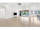 Open-concept living room with wood floors, a ceiling fan, and sliding glass doors leading to a pool area at 310 Lake Tahoe Ct, Englewood, FL 34223
