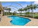 Backyard oasis featuring a screened-in pool, a hot tub, a beautiful lake view and tropical landscaping at 310 Lake Tahoe Ct, Englewood, FL 34223