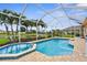 Gorgeous pool and spa enclosed with screen, surrounded by lush landscaping, with a lake view at 310 Lake Tahoe Ct, Englewood, FL 34223