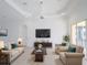 Spacious living room featuring light beige sofas and a large TV at 310 Lake Tahoe Ct, Englewood, FL 34223