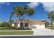 Single-story home with three palm trees and a two-car garage at 310 Lake Tahoe Ct, Englewood, FL 34223