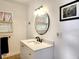 A bathroom with a marble vanity countertop, black plumbing fixtures, and a contemporary light fixture and mirror at 1810 28Th W St, Bradenton, FL 34205