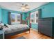 Bedroom with teal walls, hardwood floors, and a ceiling fan at 1810 28Th W St, Bradenton, FL 34205