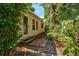 Quaint home exterior with a garden path, surrounded by lush greenery, offering a peaceful and private setting at 1810 28Th W St, Bradenton, FL 34205