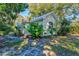 Charming single-story home featuring a light yellow exterior, a chimney, mature trees and a metal roof at 1810 28Th W St, Bradenton, FL 34205