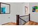 Upstairs hallway with hardwood floors, mirror, window and view of additional bedroom at 1810 28Th W St, Bradenton, FL 34205