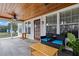 Relaxing sunroom with wood ceiling, tile floor, comfortable seating, and view of lush backyard at 1810 28Th W St, Bradenton, FL 34205