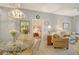 Bright dining area with a glass table and wicker chairs adjoined to a living room at 4208 Central Sarasota Pkwy # 1412, Sarasota, FL 34238