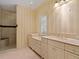Bathroom with a large shower, striped wallpaper, and updated vanity at 4521 Bay Shore Rd, Sarasota, FL 34234
