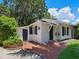 Home's exterior showcasing a white-painted bungalow and brick patio at 4521 Bay Shore Rd, Sarasota, FL 34234