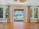 Bright living room with hardwood floors and stunning water views from sliding glass doors at 4521 Bay Shore Rd, Sarasota, FL 34234
