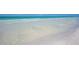 Clear, shallow water gently lapping the white sand beach at 5920 Midnight Pass Rd # 104, Sarasota, FL 34242