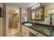 Updated bathroom with granite vanity, glass block shower, and large mirror at 5920 Midnight Pass Rd # 104, Sarasota, FL 34242
