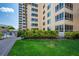 Condo building exterior with lush landscaping and walkway at 5920 Midnight Pass Rd # 104, Sarasota, FL 34242