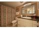 Bathroom with granite vanity, updated fixtures, and patterned shower curtain at 5920 Midnight Pass Rd # 104, Sarasota, FL 34242