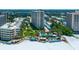 Aerial view of beachfront condo building with pool and tennis courts at 5920 Midnight Pass Rd # 104, Sarasota, FL 34242