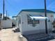 Mobile home with teal roof and awning, next to a shed at 10315 Cortez W Rd # 60-4, Bradenton, FL 34210