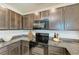 Kitchen with dark cabinets, granite countertops, and black appliances at 3902 Willow Hammock Dr, Palmetto, FL 34221