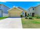 Tan house with two-car garage and landscaped yard at 3902 Willow Hammock Dr, Palmetto, FL 34221