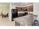 Kitchen with dark cabinets, granite counters, and a breakfast bar at 3902 Willow Hammock Dr, Palmetto, FL 34221