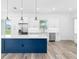 Modern kitchen with white cabinets, stainless steel appliances, and a blue island at 4593 Targee Ave, North Port, FL 34287