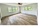 Spacious bedroom with wood-look floors, ceiling fan, and bright windows at 3637 Mineola Dr, Sarasota, FL 34239