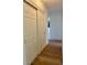 Bright hallway featuring wood floors, white trim, and a closet with white paneled sliding doors at 3637 Mineola Dr, Sarasota, FL 34239