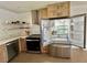 Bright kitchen features stainless steel appliances, tile floor, light wood cabinets and open shelving at 3637 Mineola Dr, Sarasota, FL 34239