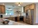 Bright kitchen featuring stone countertops, stainless steel appliances, natural wood cabinets, and ample counterspace at 3637 Mineola Dr, Sarasota, FL 34239