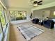 Bright living room featuring large windows, neutral tile flooring, ceiling fan, and comfortable seating area at 3637 Mineola Dr, Sarasota, FL 34239