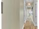 Long hallway with light wood floors and neutral walls at 2510 Gulf N Dr, Bradenton Beach, FL 34217