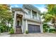 Two-story home with a gray garage door and wooden staircase at 2510 Gulf N Dr, Bradenton Beach, FL 34217