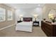 Cozy bedroom with wood dresser and white bedding at 12014 Perennial Pl, Lakewood Ranch, FL 34211