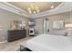 Bright and spacious main bedroom with a comfortable seating area and a large TV at 12014 Perennial Pl, Lakewood Ranch, FL 34211