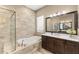 Spa-like bathroom with soaking tub, walk-in shower, and modern fixtures at 12014 Perennial Pl, Lakewood Ranch, FL 34211