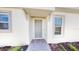Front entry with gray door and brick walkway at 16132 Ivy Ridge Ct, Port Charlotte, FL 33953