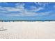 Beach with lounge chairs and umbrellas under a bright sky at 1300 N Portofino Dr # 305, Sarasota, FL 34242
