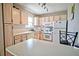 Kitchen with light wood cabinets, white appliances and tile backsplash at 4460 Ironwood Cir # 301A, Bradenton, FL 34209